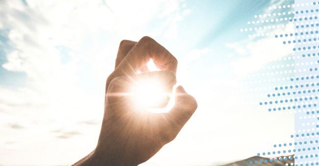 A hand around the sunlight in the sky